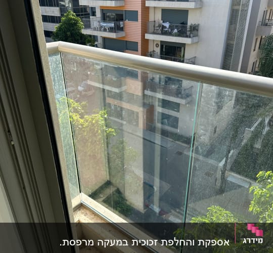 מעקה זכוכית במרפסת עם נוף לבניינים
